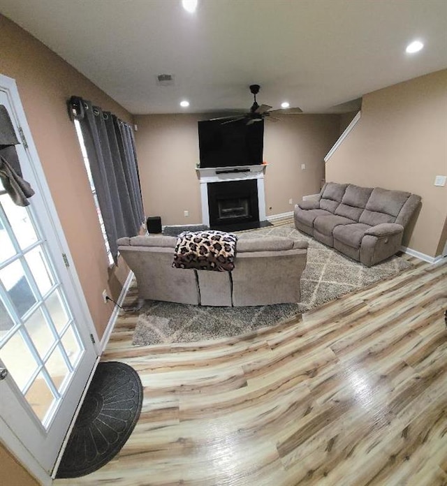 living room with light wood-type flooring and ceiling fan