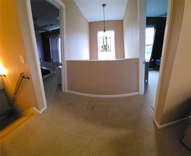 corridor featuring carpet floors and a chandelier