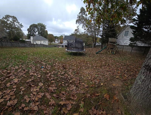 view of yard featuring a playground and a trampoline