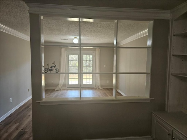 unfurnished room with hardwood / wood-style flooring, crown molding, and a textured ceiling