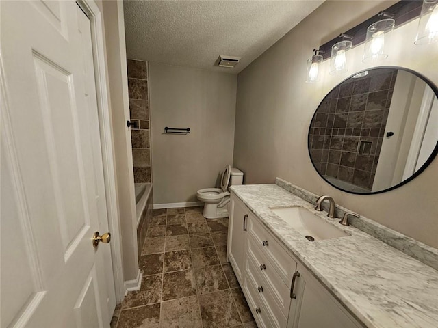 full bathroom featuring vanity, toilet, tiled shower / bath combo, and a textured ceiling