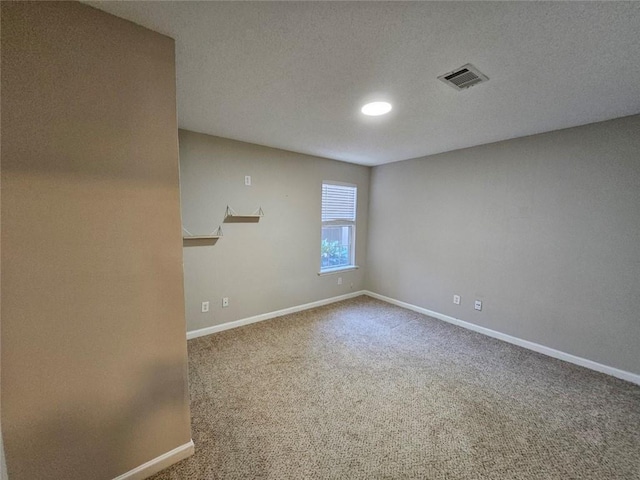 carpeted empty room featuring a textured ceiling