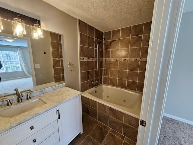 bathroom with tiled shower / bath, vanity, and a textured ceiling