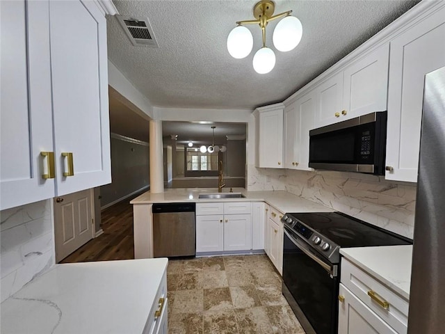 kitchen with pendant lighting, tasteful backsplash, white cabinetry, sink, and stainless steel appliances