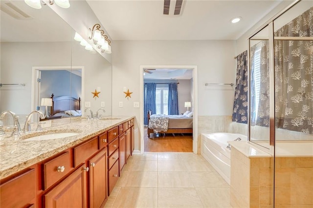 bathroom with tile patterned flooring, vanity, and independent shower and bath