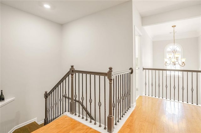 staircase with a chandelier and wood-type flooring