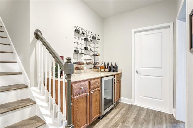 bar featuring beverage cooler and light wood-type flooring