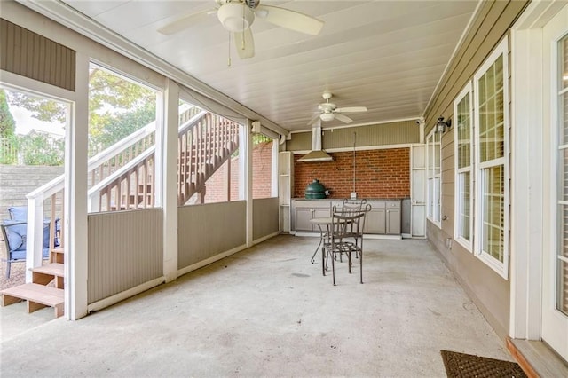 unfurnished sunroom with ceiling fan