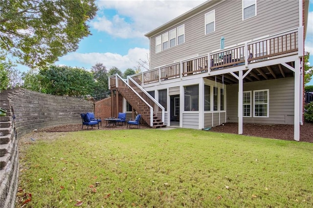 back of house with a yard, a wooden deck, and a sunroom