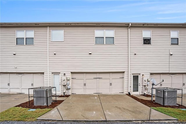 back of property with a garage and cooling unit