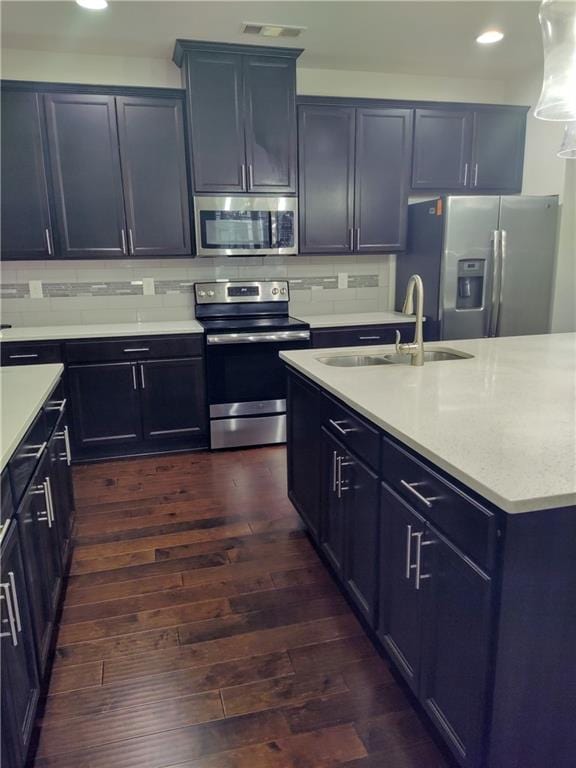 kitchen with decorative backsplash, appliances with stainless steel finishes, dark hardwood / wood-style flooring, and sink