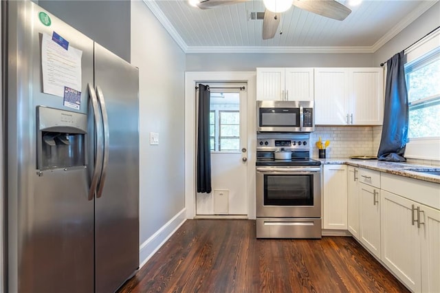 kitchen with tasteful backsplash, appliances with stainless steel finishes, light stone counters, dark wood-type flooring, and ornamental molding