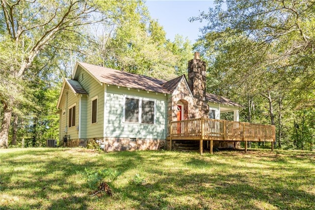 rear view of house with cooling unit, a deck, and a yard