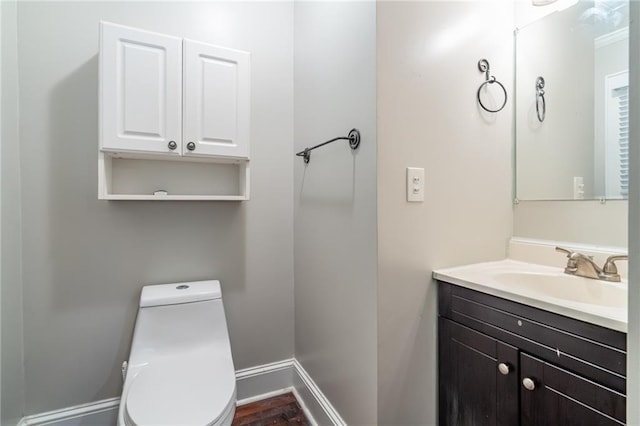 bathroom featuring baseboards, vanity, and toilet