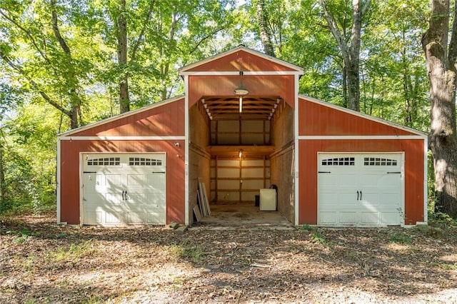 garage featuring a detached garage and dirt driveway