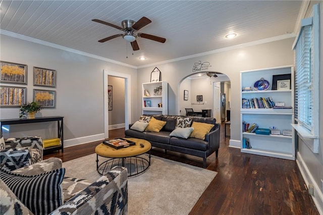 living room with dark wood-type flooring, arched walkways, and crown molding