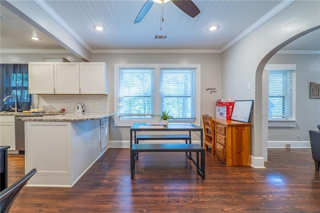 kitchen with visible vents, light stone counters, white cabinets, and a wealth of natural light