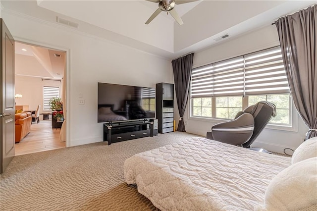 bedroom with multiple windows, light colored carpet, and ceiling fan