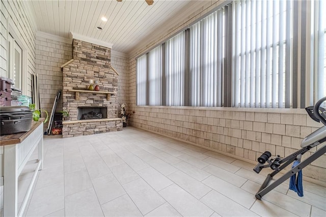 unfurnished living room featuring a wealth of natural light, a fireplace, ceiling fan, and wooden ceiling