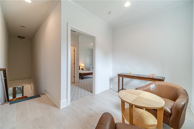 living area featuring light hardwood / wood-style flooring and ornamental molding