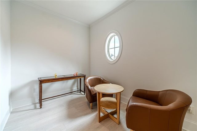 sitting room with light wood-type flooring and crown molding