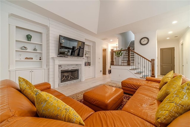 living room featuring built in features and a fireplace