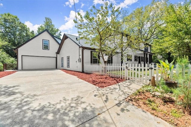 view of front of home featuring concrete driveway, a garage, and a fenced front yard