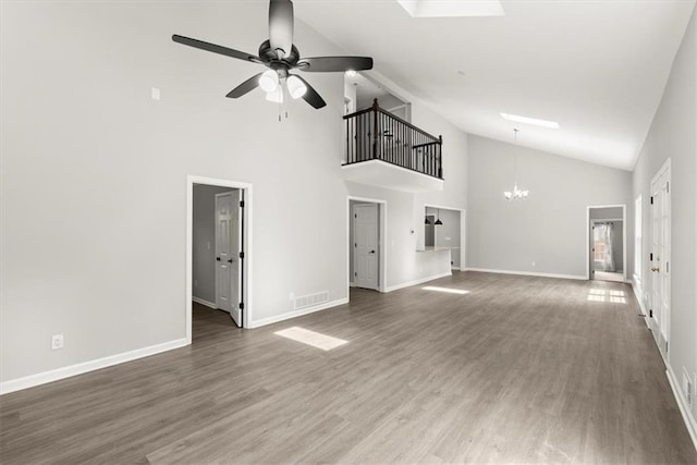 unfurnished living room with visible vents, ceiling fan with notable chandelier, baseboards, and wood finished floors