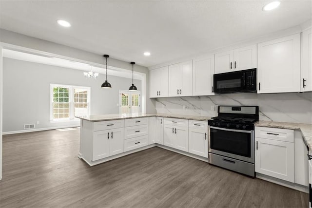 kitchen featuring white cabinetry, a peninsula, black microwave, decorative backsplash, and stainless steel gas range