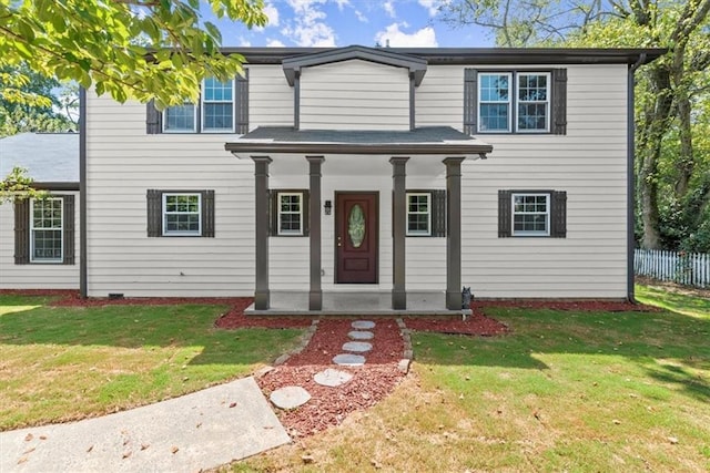 view of front facade featuring covered porch, a front lawn, and fence