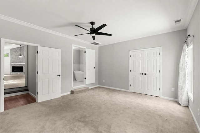 unfurnished bedroom featuring crown molding, carpet flooring, baseboards, and visible vents