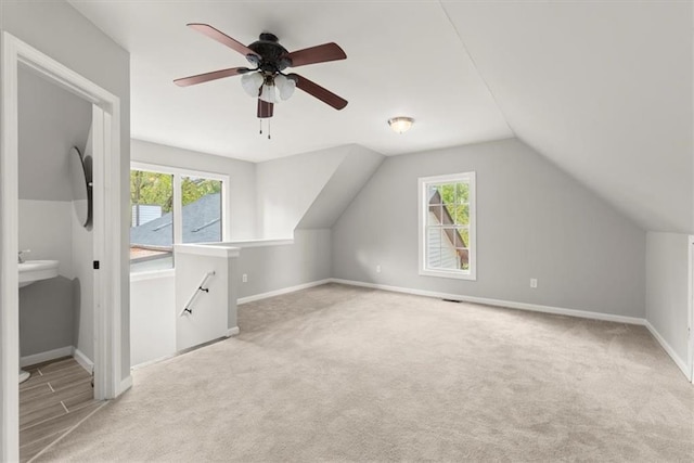 additional living space featuring a healthy amount of sunlight, baseboards, carpet, and ceiling fan