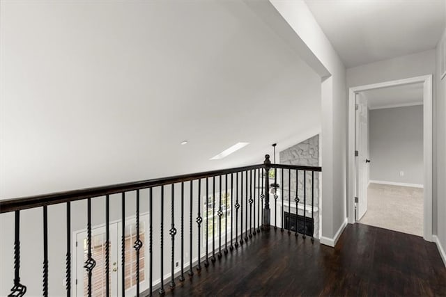 corridor featuring wood finished floors and baseboards