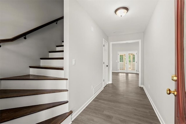 foyer entrance featuring french doors, baseboards, wood finished floors, and stairs