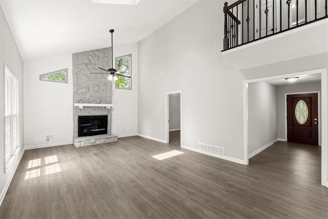 unfurnished living room with visible vents, dark wood-type flooring, baseboards, ceiling fan, and a fireplace