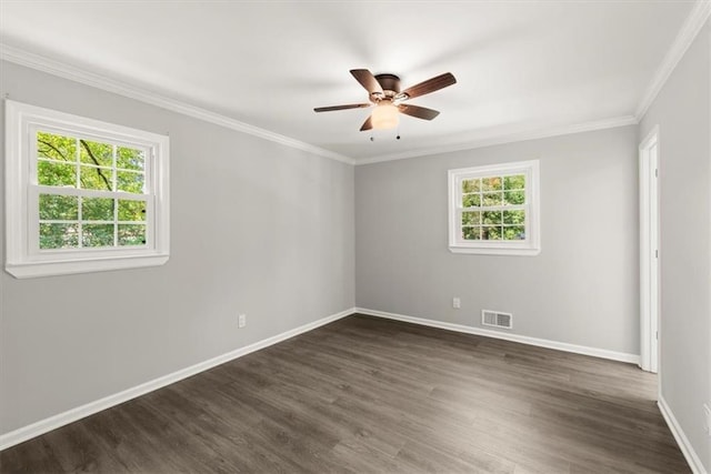 empty room with dark wood-style floors, baseboards, visible vents, ceiling fan, and crown molding