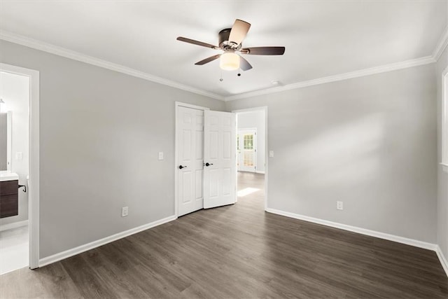 unfurnished bedroom with dark wood-style floors, baseboards, and ornamental molding