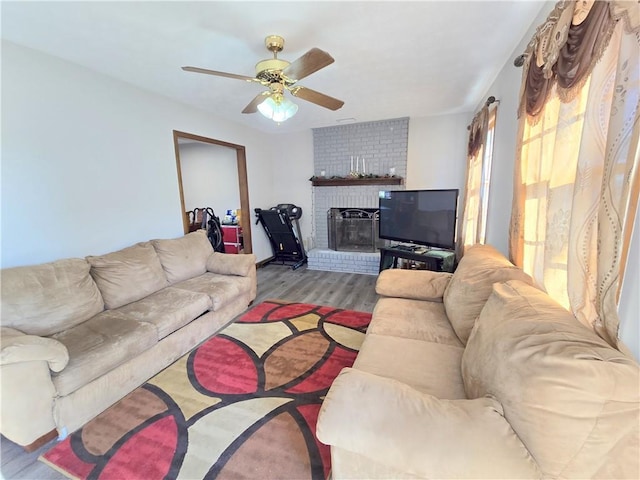 living room with a fireplace, light hardwood / wood-style floors, and ceiling fan