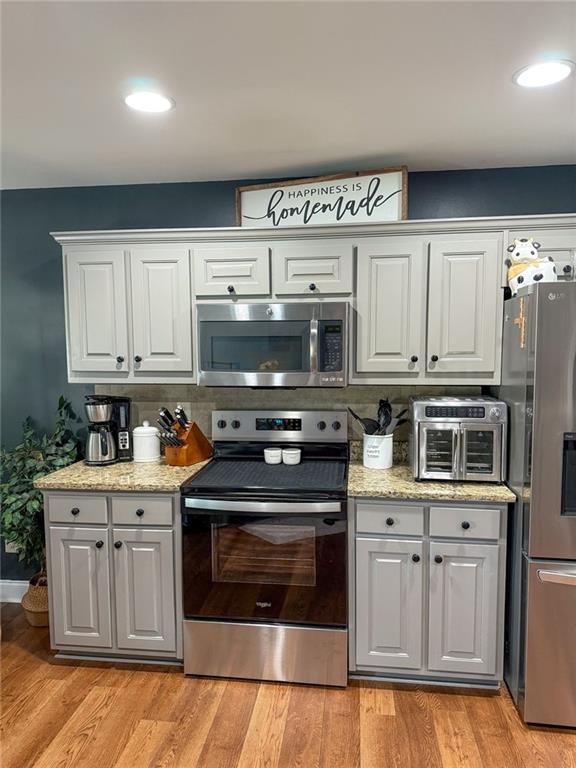 45 Albright Ct, Commerce, GA 30529 - kitchen with light wood-type flooring, appliances with stainless steel finishes, baseboards, and white cabinetry