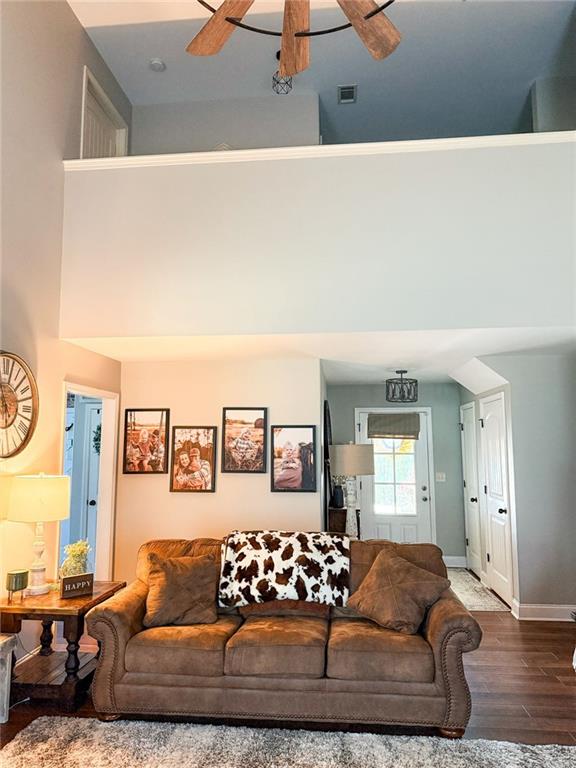 45 Albright Ct, Commerce, GA 30529 - living room featuring visible vents, baseboards, a ceiling fan, wood finished floors, and a high ceiling