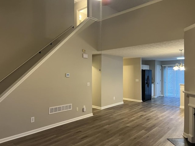 interior space with a chandelier, a high ceiling, crown molding, and dark wood-type flooring