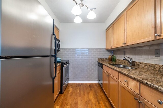 1150 Collier Rd NW Unit G8, Atlanta, GA 30318 - kitchen with stainless steel appliances, wood finished floors, wainscoting, dark stone counters, and tile walls