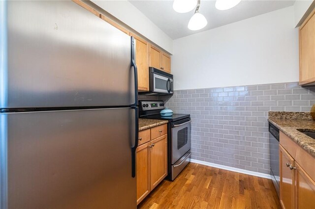 1150 Collier Rd NW Unit G8, Atlanta, GA 30318 - kitchen featuring stainless steel appliances, wood finished floors, wainscoting, stone countertops, and tile walls