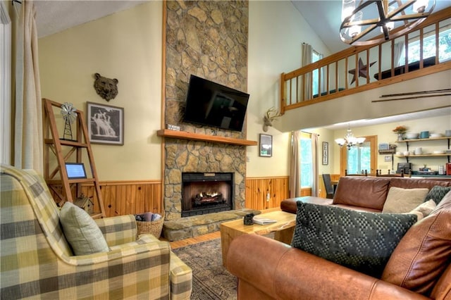 276 Pine Ridge Rd, Ellijay, GA 30536 - living room with a chandelier, wood finished floors, wainscoting, plenty of natural light, and a stone fireplace