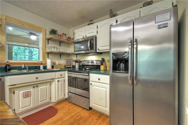 276 Pine Ridge Rd, Ellijay, GA 30536 - kitchen featuring stainless steel appliances, light wood-style flooring, a textured ceiling, dark countertops, and open shelves