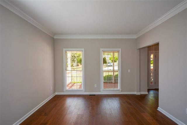 empty room with dark wood-style floors, baseboards, and crown molding