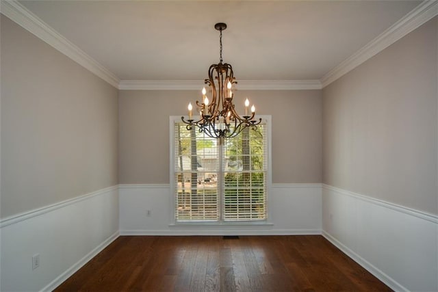 unfurnished dining area with crown molding, wood finished floors, a notable chandelier, and baseboards