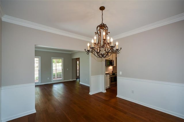 unfurnished dining area featuring dark wood-type flooring, ornamental molding, baseboards, and a notable chandelier