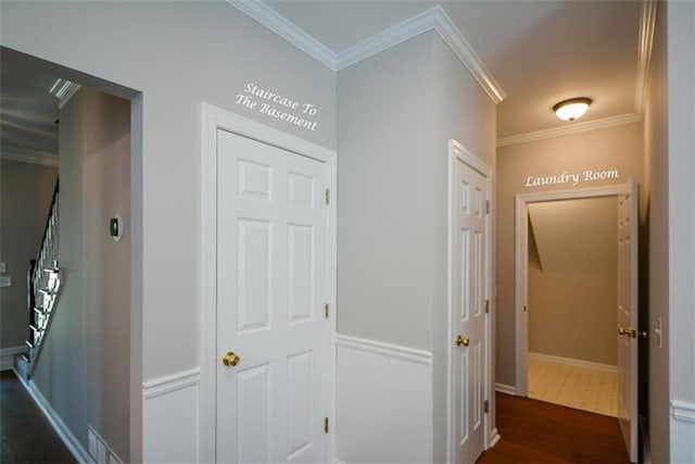 hallway featuring dark wood-type flooring, baseboards, and ornamental molding