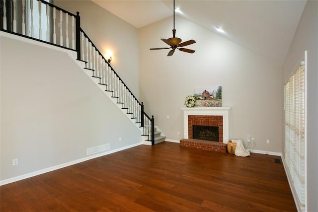 unfurnished living room featuring wood finished floors, ceiling fan, visible vents, and stairs